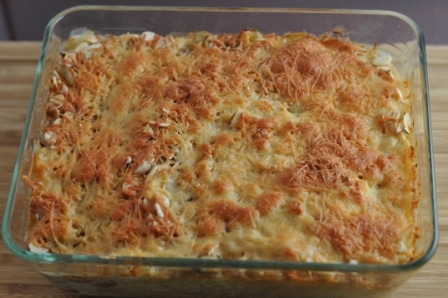 Chicken tetrazzini recipe made with spaghetti, parmesan cheese, and a creamy homemade sauce served in a clear casserole dish baked with cheese on top.