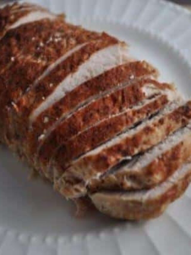 Pork Tenderloin with Cajun Seasoning cooked in the Instant Pot sliced cascading on a white plate.