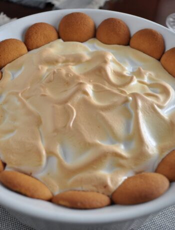 Homemade hot banana pudding topped with meringue and vanilla wafers.