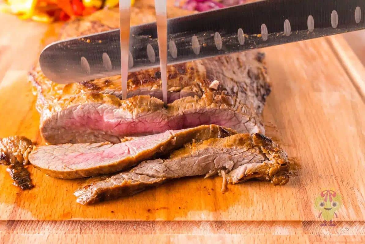 Flank Steak on a cutting board ready to serve.