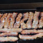 Bacon cooking on a Blackstone Griddle.