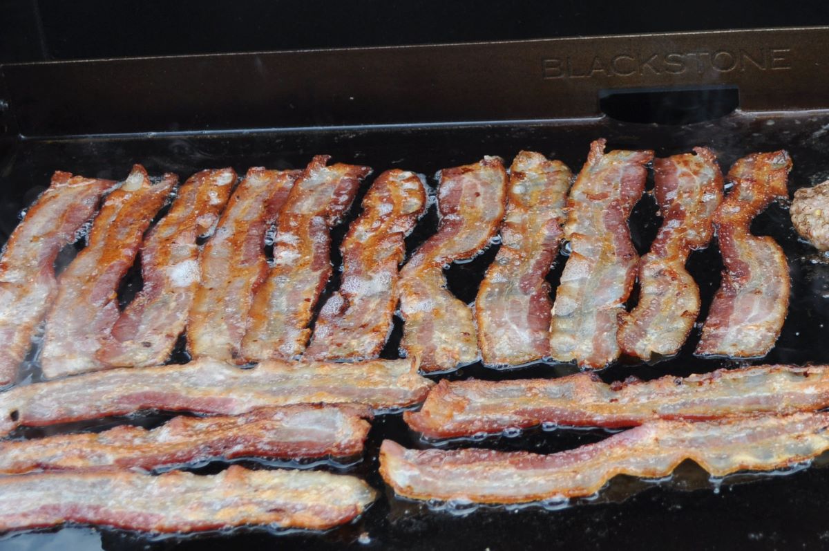 Bacon cooking on a Blackstone Griddle.