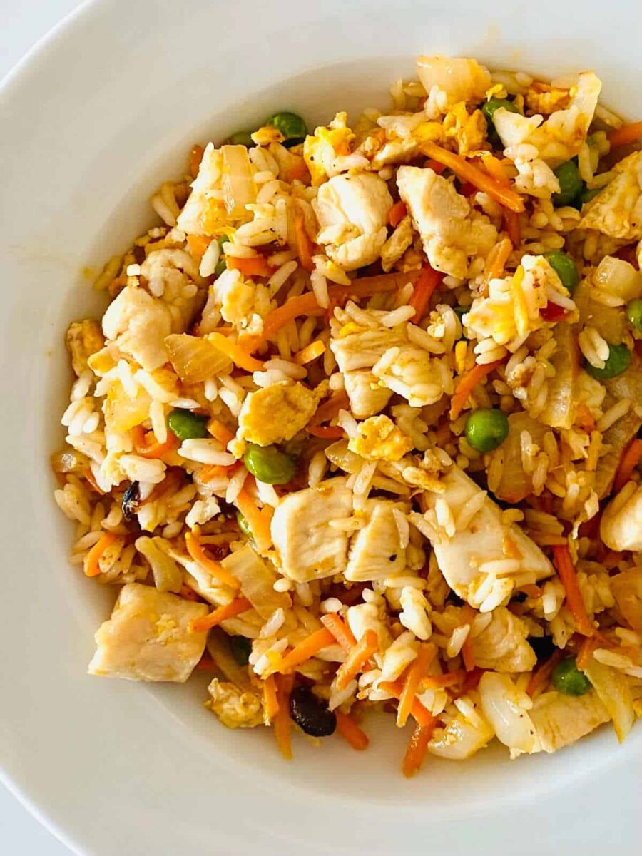 Hibachi fried rice prepared on a Blackstone griddle with rice, peas, carrots, onion and chicken.