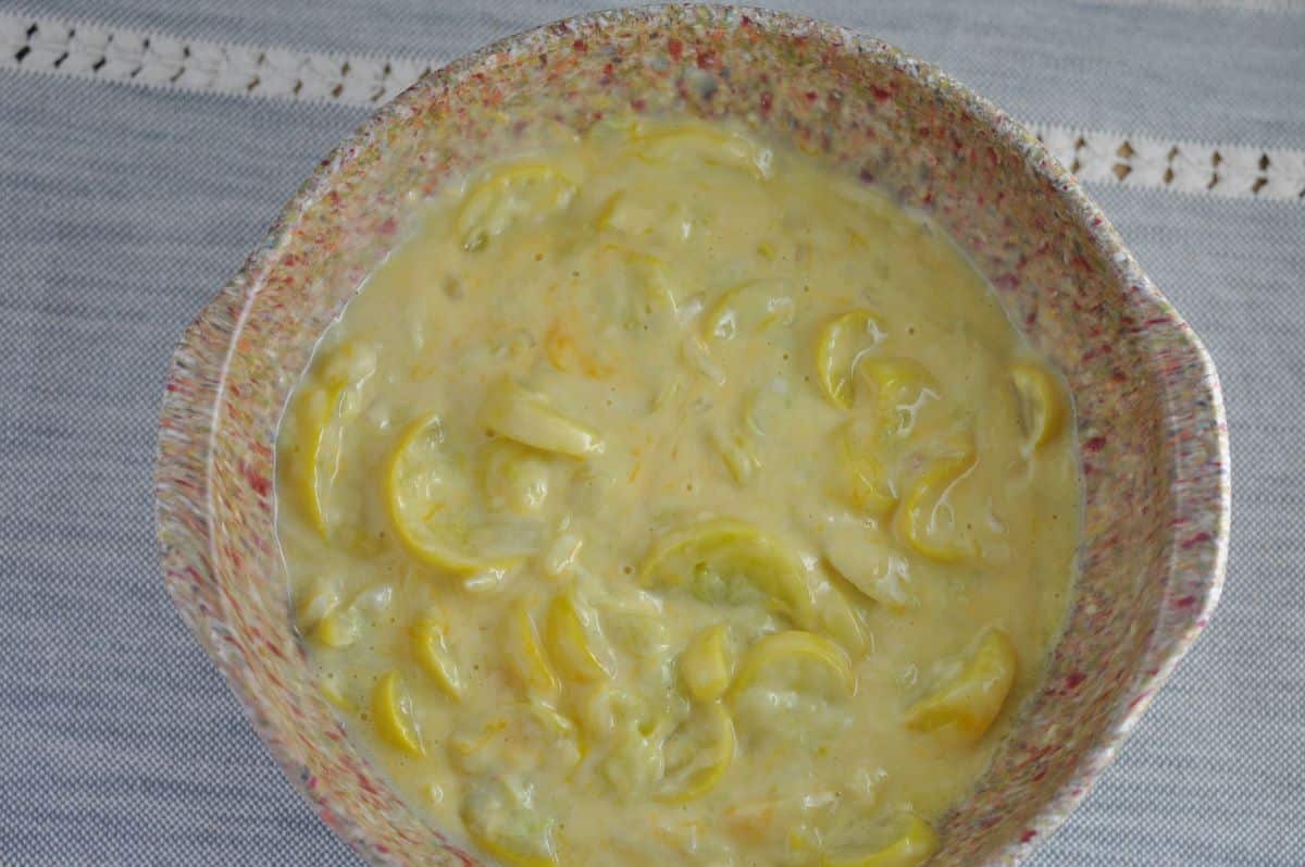 Easy squash casserole recipe ingredients include mixed squash casserole ingredients in a large bowl.
