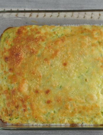 Zucchini souffle baked in a casserole dish topped with parmesan cheese and cooked until golden brown.