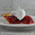 Strawberry pie topped with whip cream.