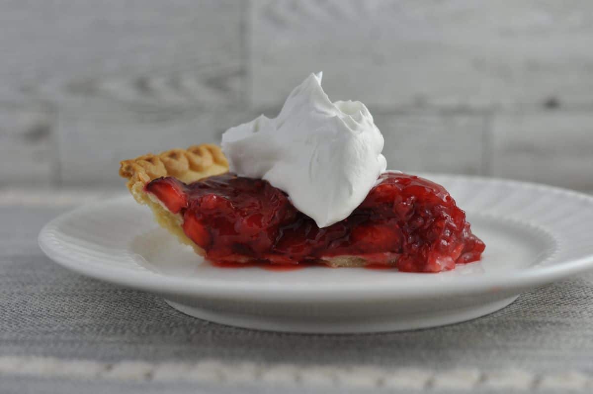 Strawberry pie topped with whip cream.